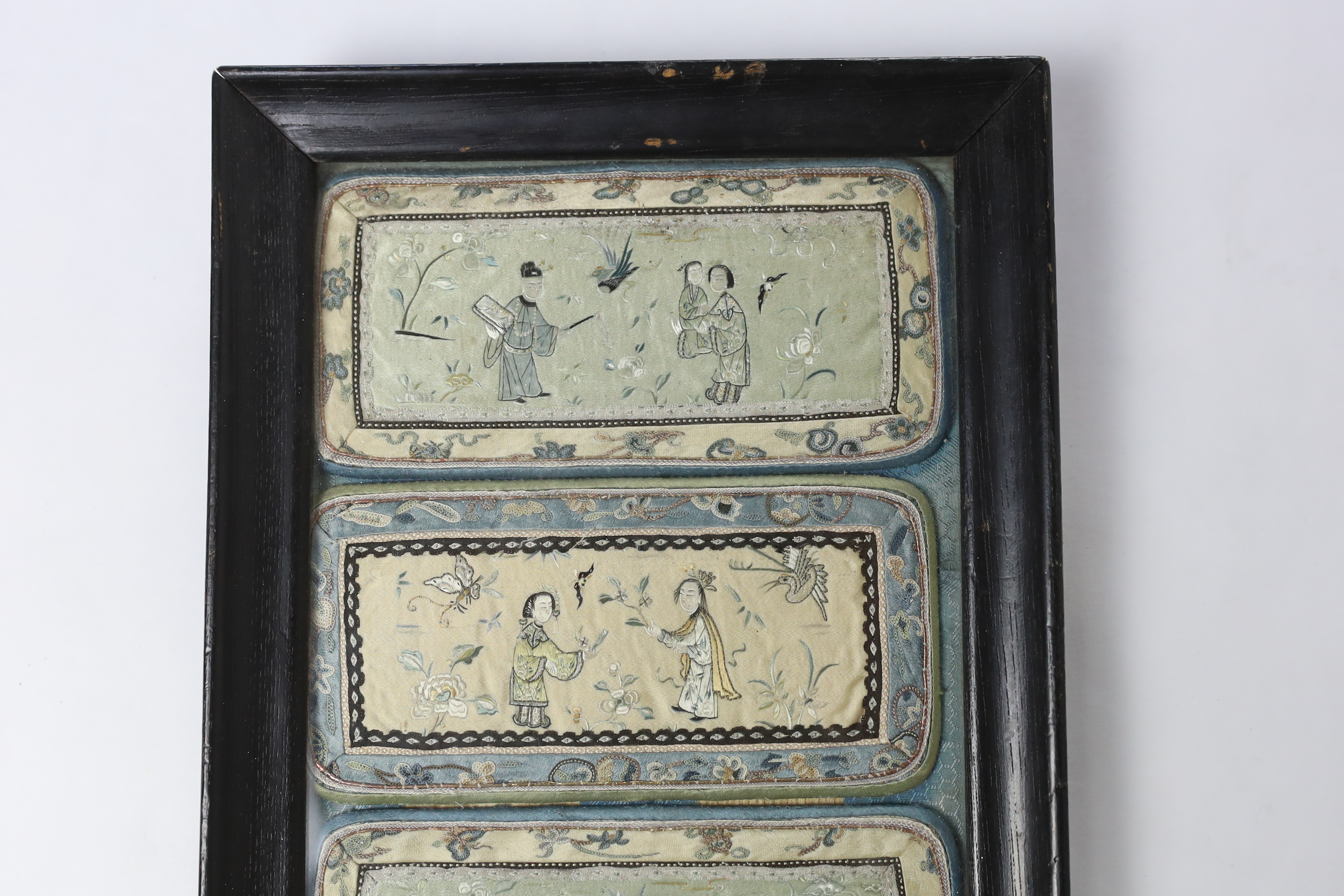 Two pairs of Chinese silk figurative embroidered panels (framed together), being the front and back panels of two spectacle cases, embroidered with very fine embroidery, using Chinese knot in the borders, 15.5cm wide x 3